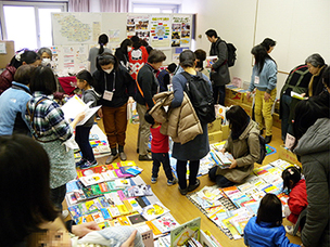 子どもの本のリサイクル市で本を探す親子