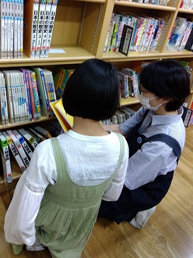 図書館で調べものをする児童の写真