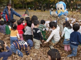 写真：落ち葉プールで遊ぶ子どもたち