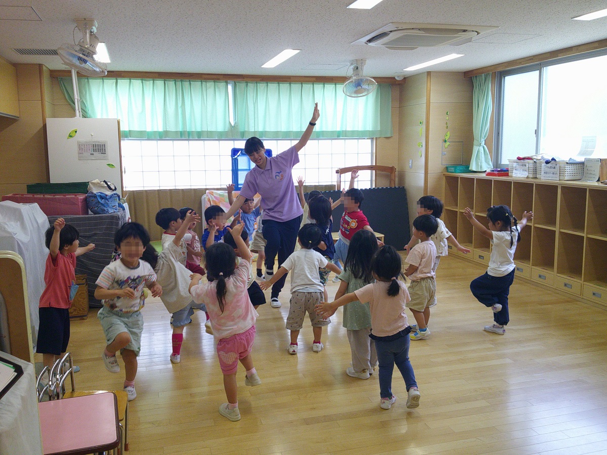 担任と踊る園児