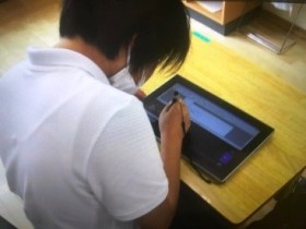 タブレット端末に専用ペンを使って、記入している様子