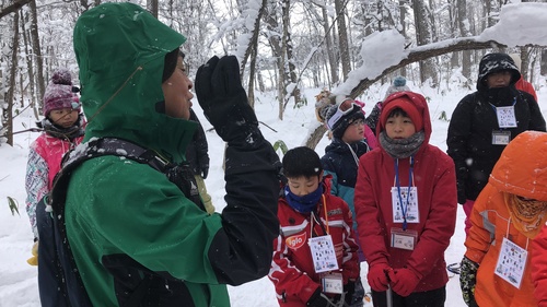 写真：スノーシューをしながら説明を受ける子供たち